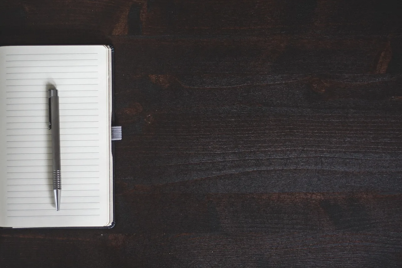 notebook, pen, table, gray laptop, gray table, notebook, notebook, notebook, pen, pen, pen, pen, pen, table, table, table