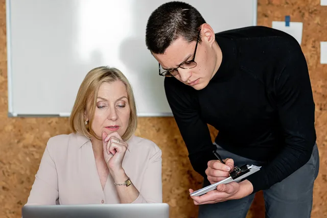 Two colleagues collaborating during a business meeting, focused on planning and communication. Mitarbeitergespräche führen: Ablauf, Fragen und Dokumentation